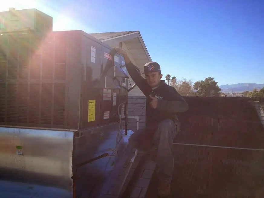 HVAC technician performing Boiler Repair on a rooftop unit in Dayton